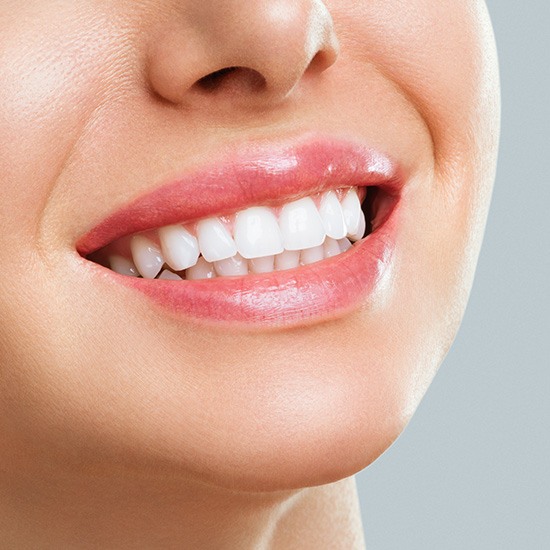 Nose to chin view of woman with whitened teeth smiling