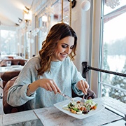 Woman smiling while eating lunch at restaurant